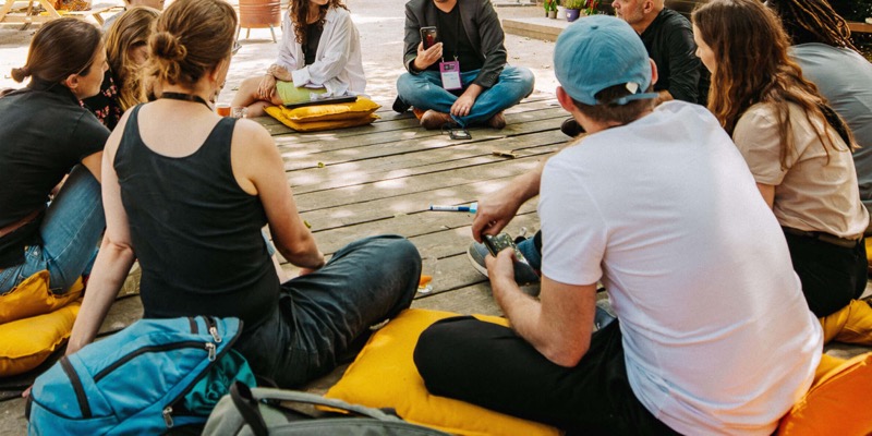 People sitting in a circle on the floor sharing ideas.